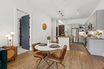 A modern kitchen with a dining table set for two.